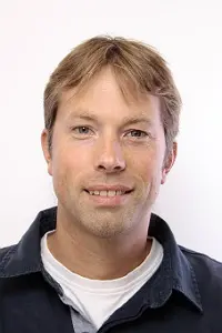 Glad man som tittar in i kameran