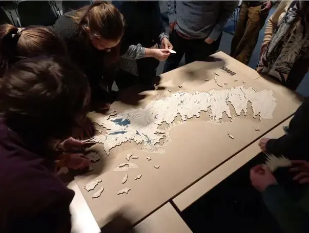 Personer som tittar på och jobbar med hydrogafisk data på ett papper på ett bord.