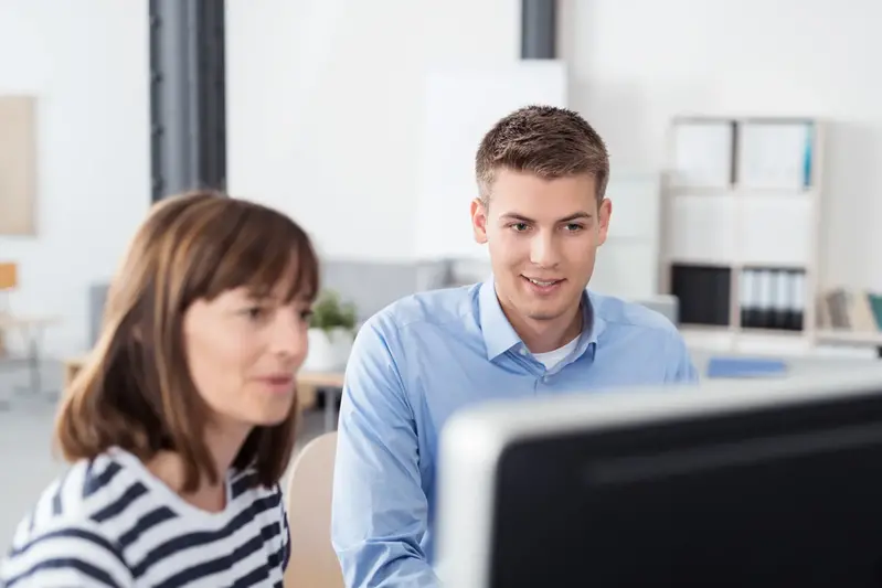 Två personer sitter vid en dataskärm.