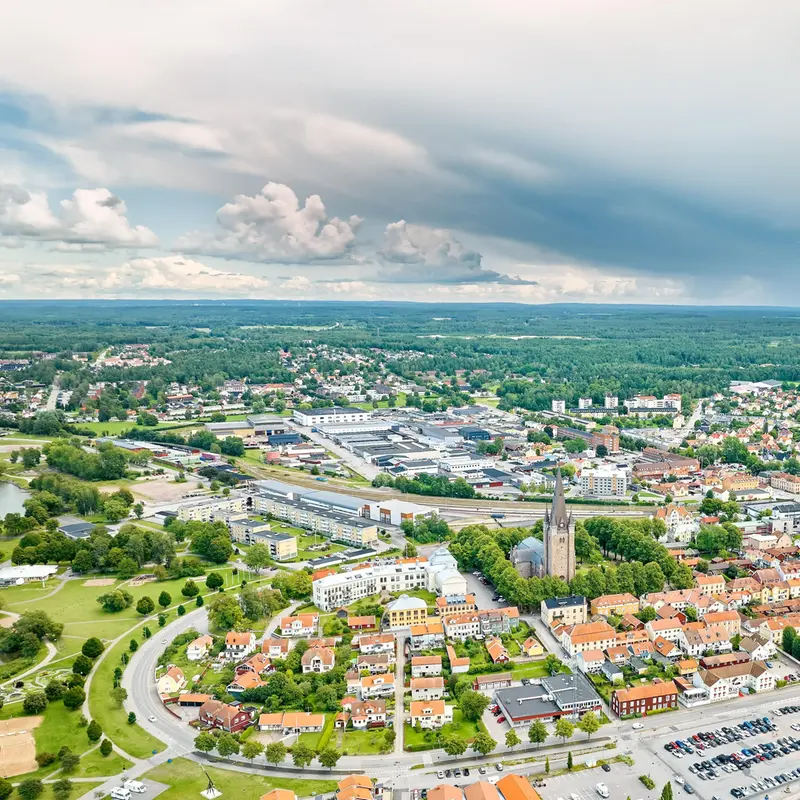 Landskapsbild över Mariestad med omnejd med tunga moln som kommer in från höger i bild.