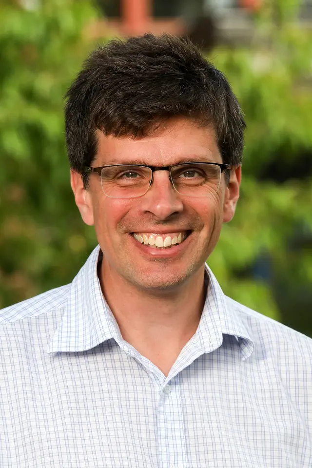 Man med glasögon som ler