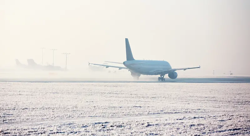 Flygplan på en snöig startbana.