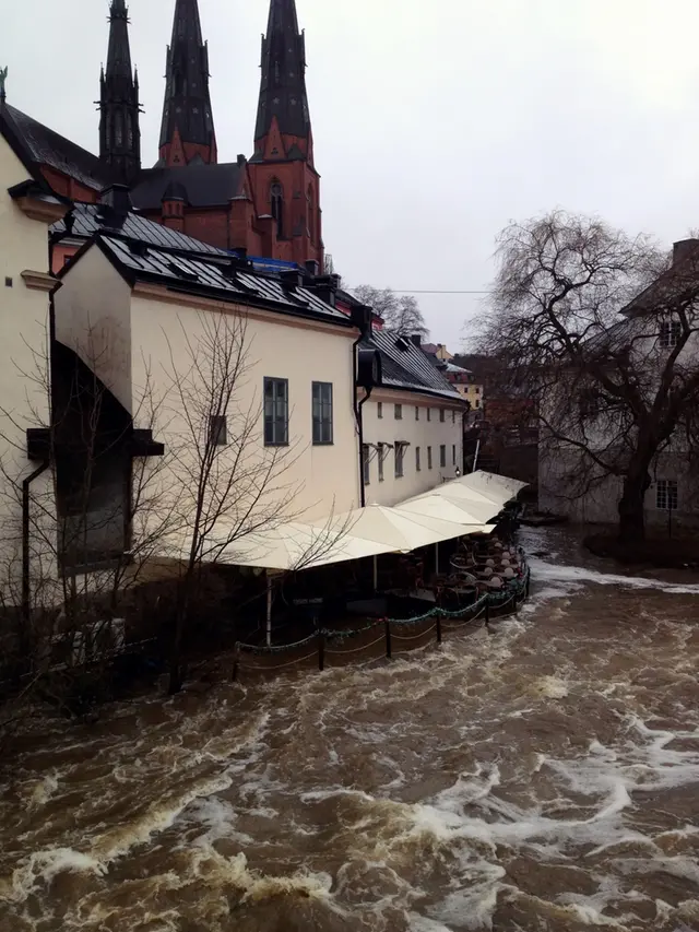 Uteservering är översvämmad vid ett högt flöde i Fyrisån i Uppsala.