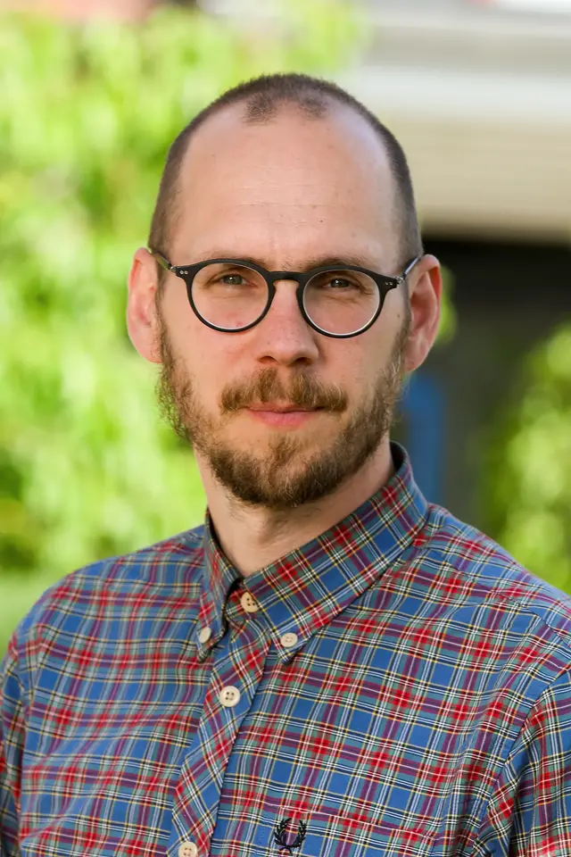 Man med glasögon och skjorta