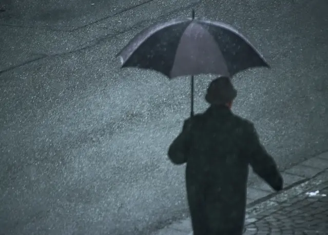 Person som går med paraply i regn